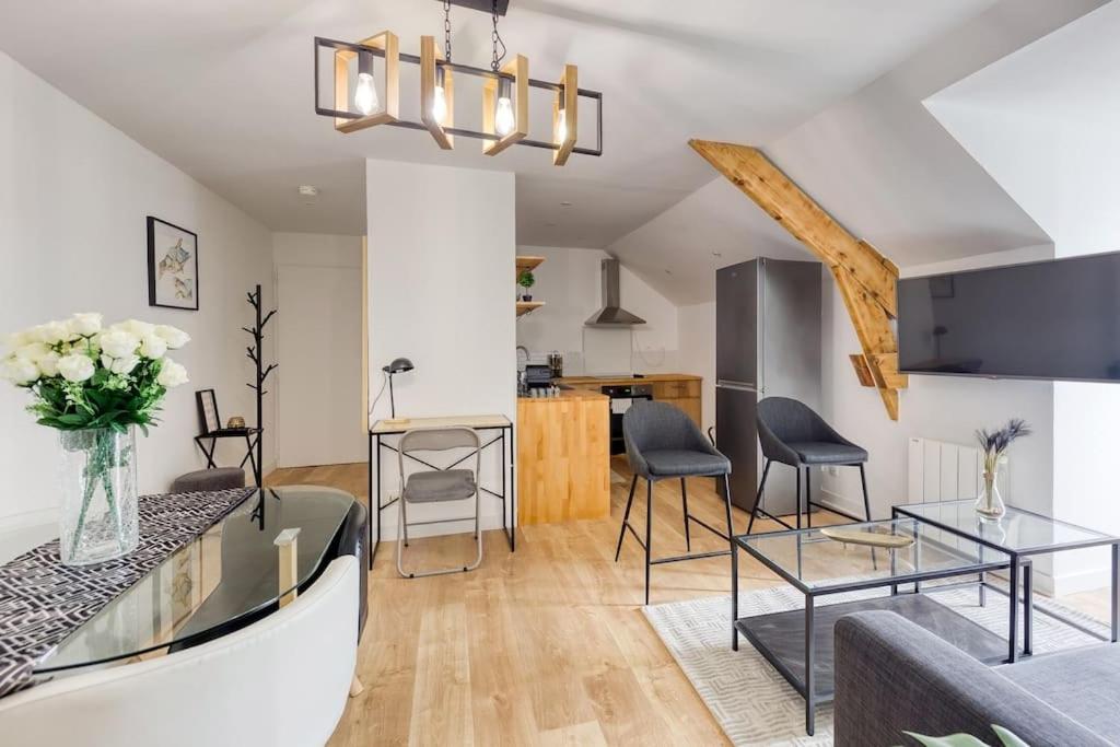 a living room with a couch and a table at Le cosy in Saint-Cyr-lʼÉcole