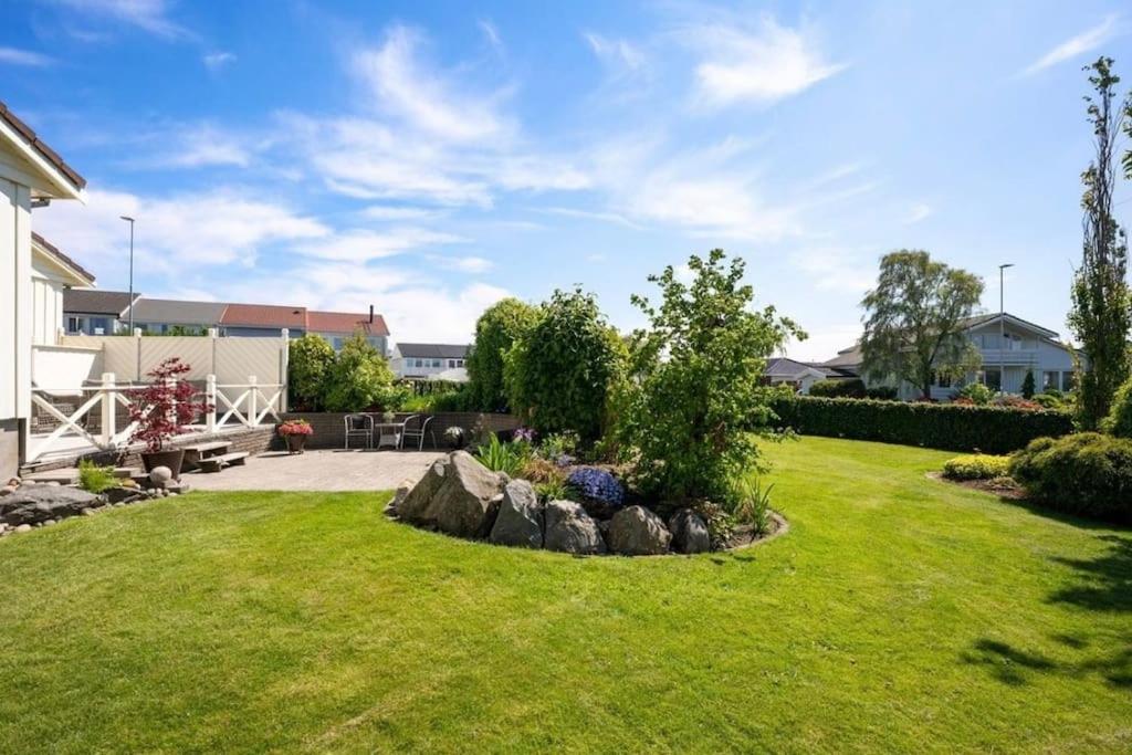 a garden with a rock in the middle of a yard at Leilighet til leie på Klepp nært Borestranden in Klepp