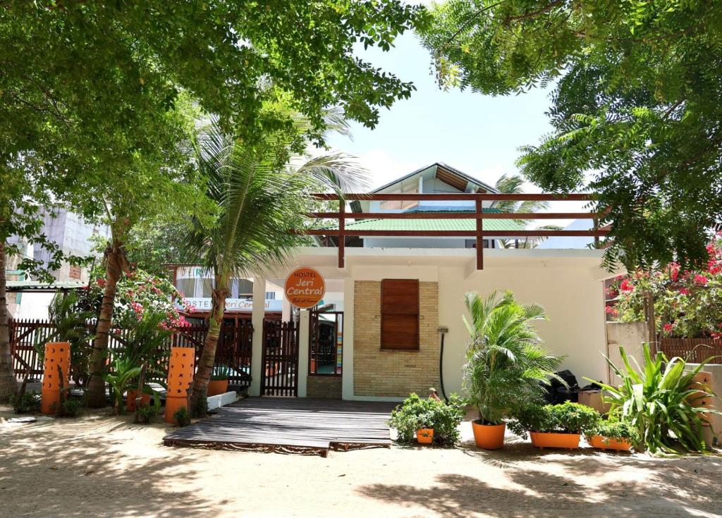 a house with a fence and trees and plants at Hostel Jeri Central in Jericoacoara