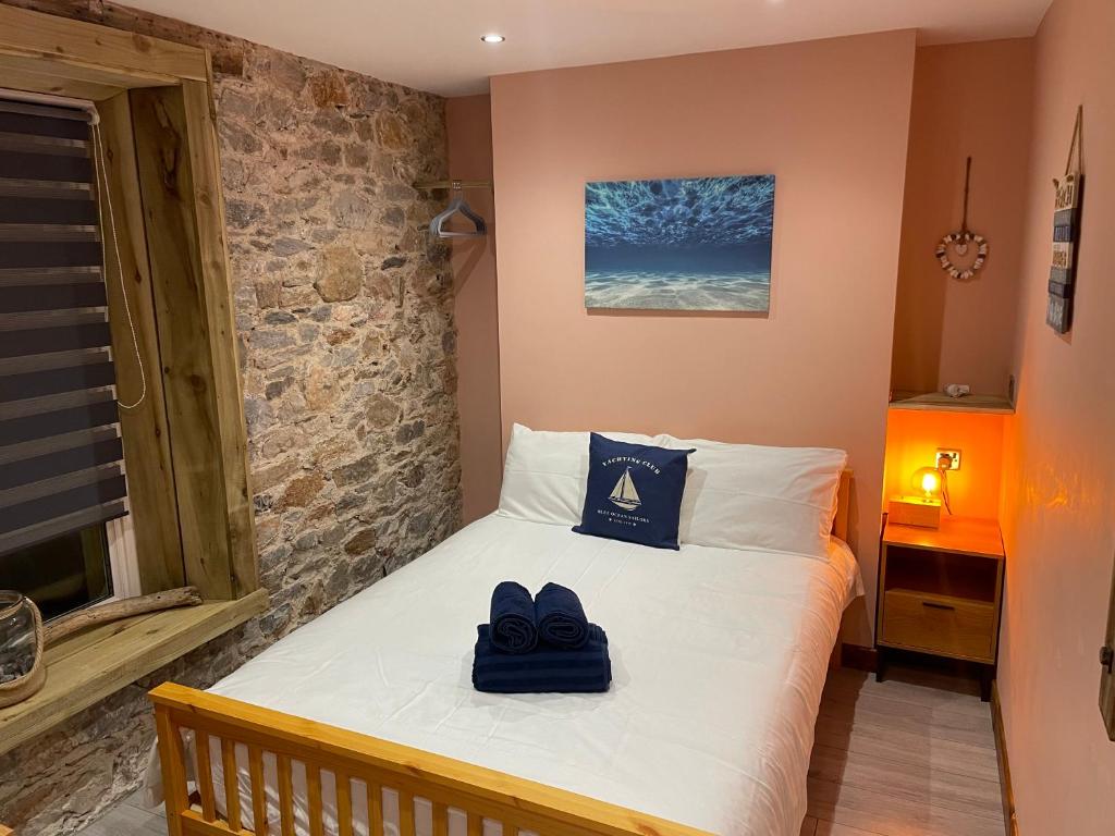 a bedroom with a bed with two hats on it at ISLAND LODGE on the Hoe, Barbican, Free Limited Parking, Dogs friendly , Perfect for Ferry terminal in Plymouth