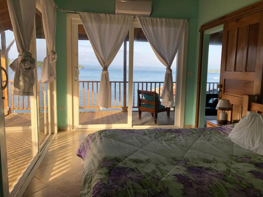 a bedroom with a bed and a view of the ocean at Sunset View in Bastimentos