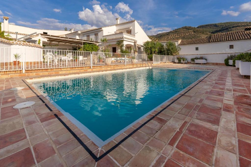 a swimming pool in front of a house at Vivienda Rural Las Bartolas in Jaén