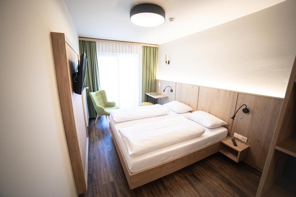 una camera d'albergo con due letti e una finestra di Finkensteiner Hof a Finkenstein am Faaker See