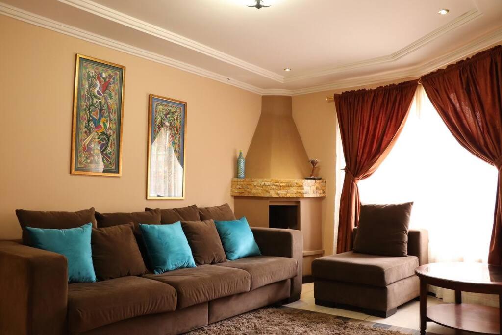 a living room with a brown couch and blue pillows at Cozy and Spacious Home with Incredible Location in Cuenca