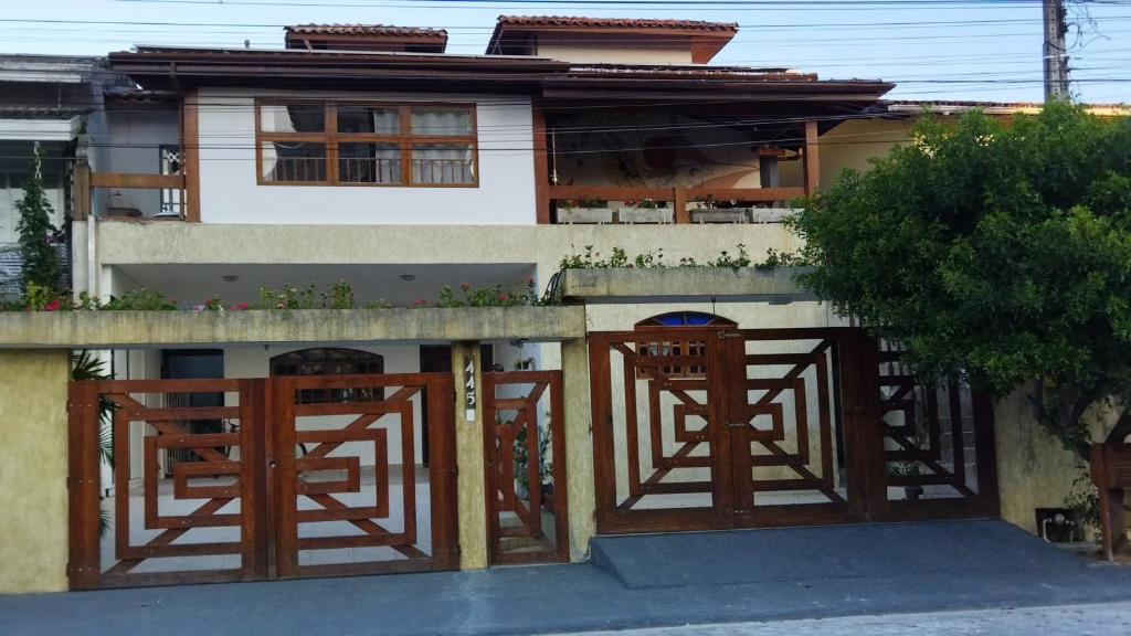 una casa con due porte di legno davanti di Pousada Primavera a Caraguatatuba