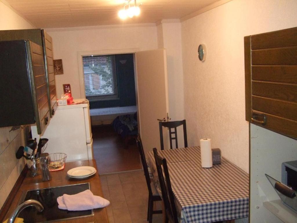 uma cozinha com uma mesa e uma pequena cozinha com um lavatório em worker-flat em Gelsenkirchen