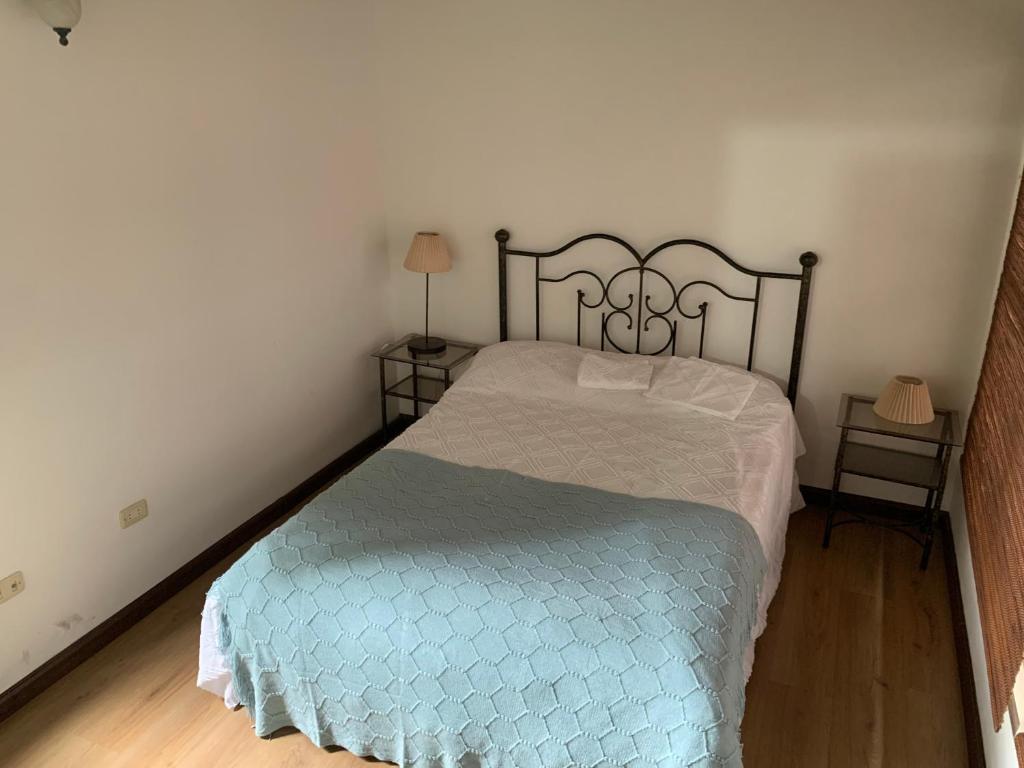 1 dormitorio con 1 cama con edredón azul en Hostal La Cestería Pueblito Boyacense, en Duitama