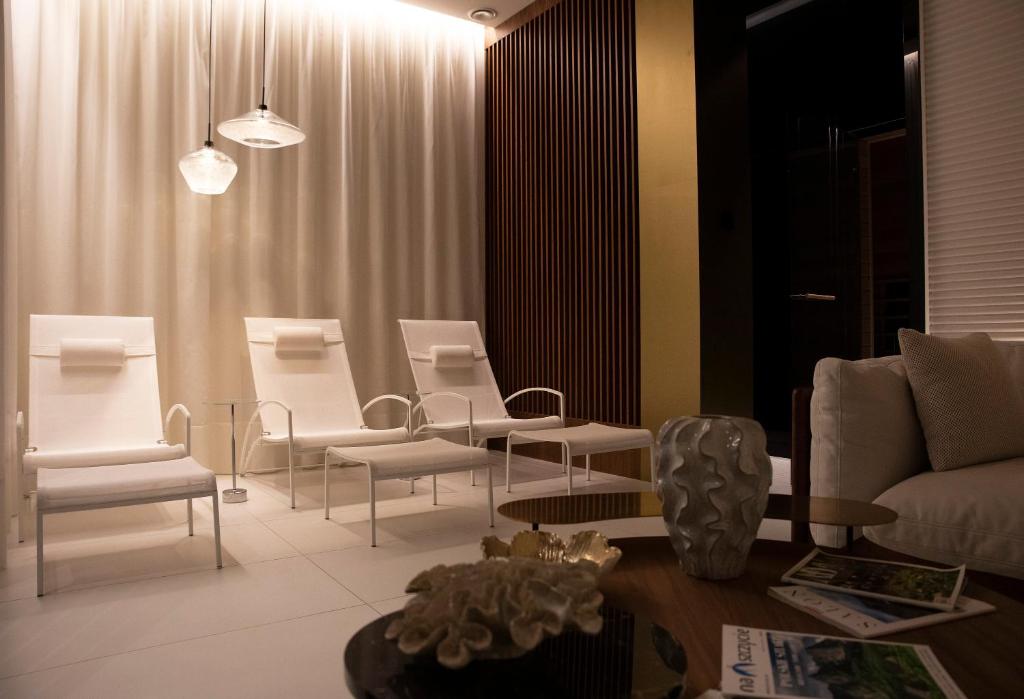 - un salon avec des chaises blanches et une table dans l'établissement Luxus Apartament Fitness&Spa z sauną i siłownią, à Gdańsk