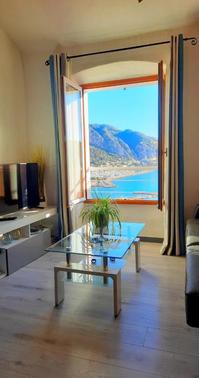 sala de estar con mesa de cristal frente a una ventana en MENTON, centre historique, vue mer, en Menton