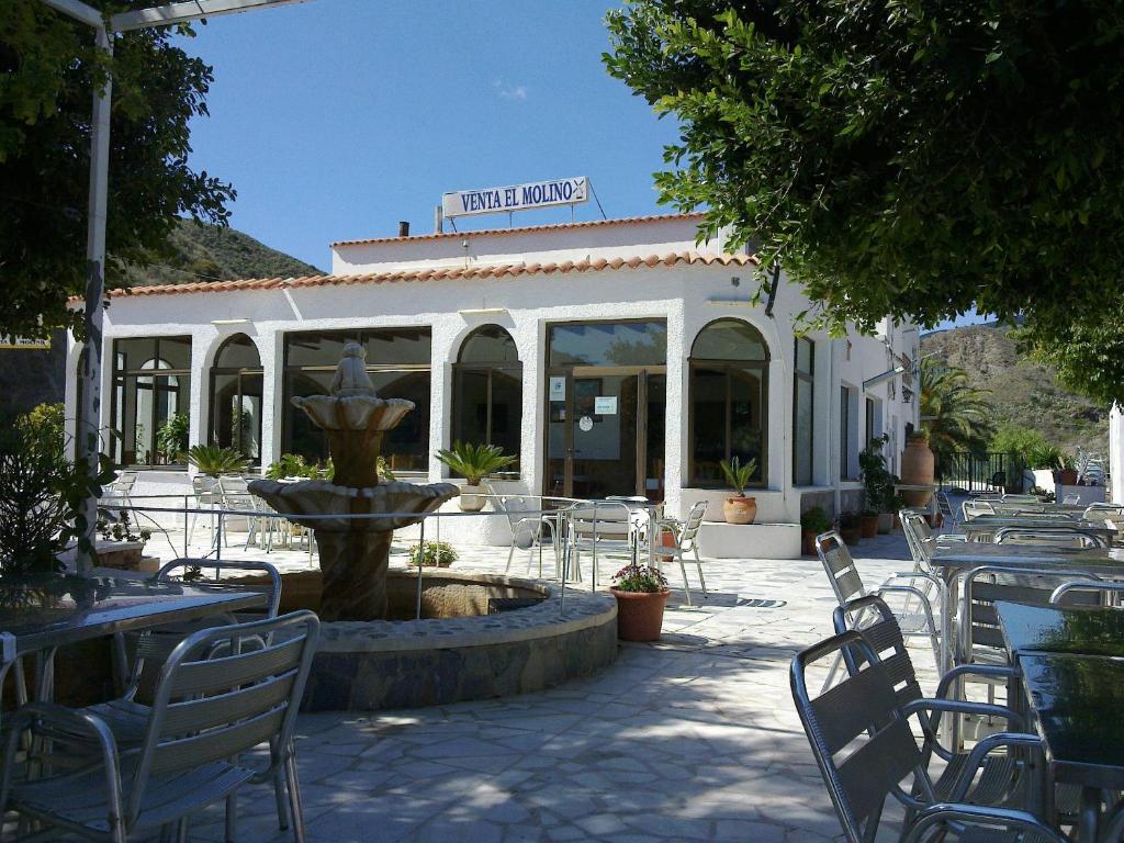 un restaurante con una fuente, mesas y sillas en Pensión Restaurante Venta El Molino, en Sopalmo