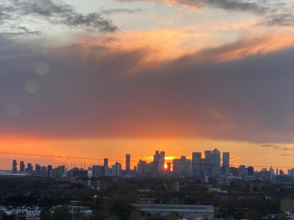 een uitzicht op de skyline van de stad bij zonsondergang bij 2 Bed Penthouse-Riverside View in East London in Barking