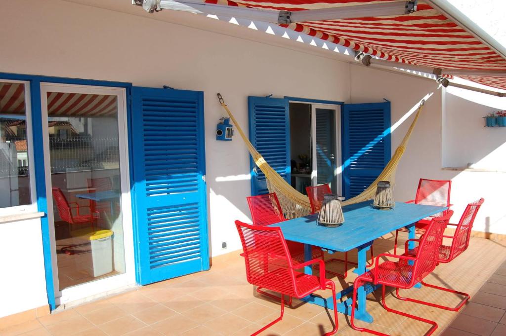 un patio con una mesa azul y sillas rojas en Great Terrace Valbom Apartment, en Cascais