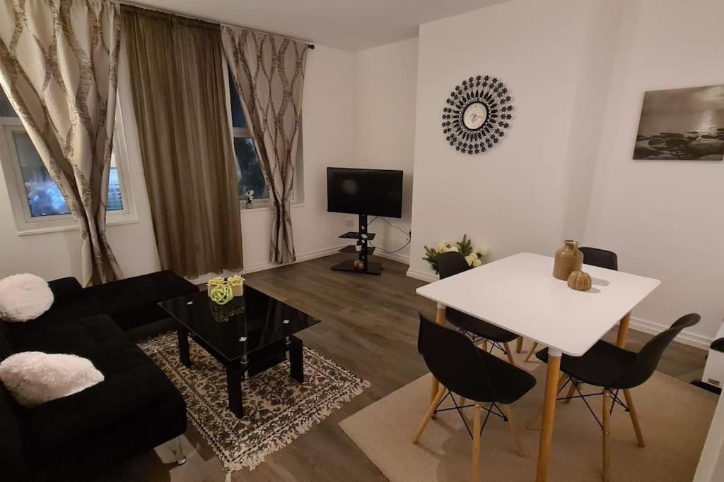 a living room with a couch and a table at Luxury 1 bedroom flat in the heart of Wood Green in London