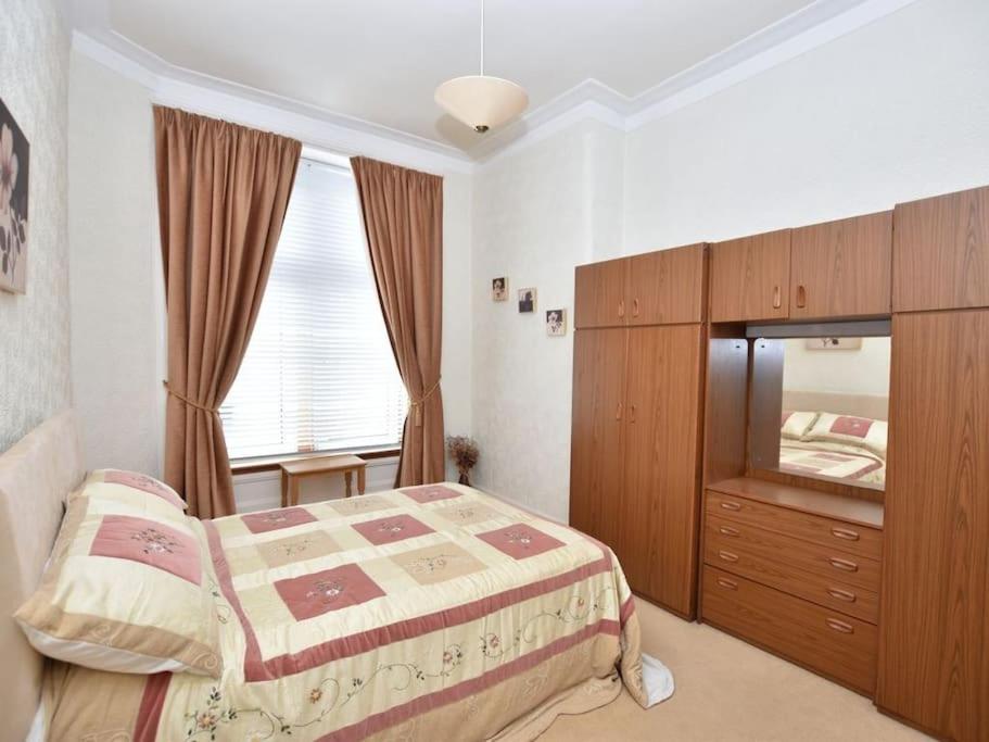 um quarto com uma cama, uma cómoda e uma janela em Lovely flat overlooking the Clyde em Gourock