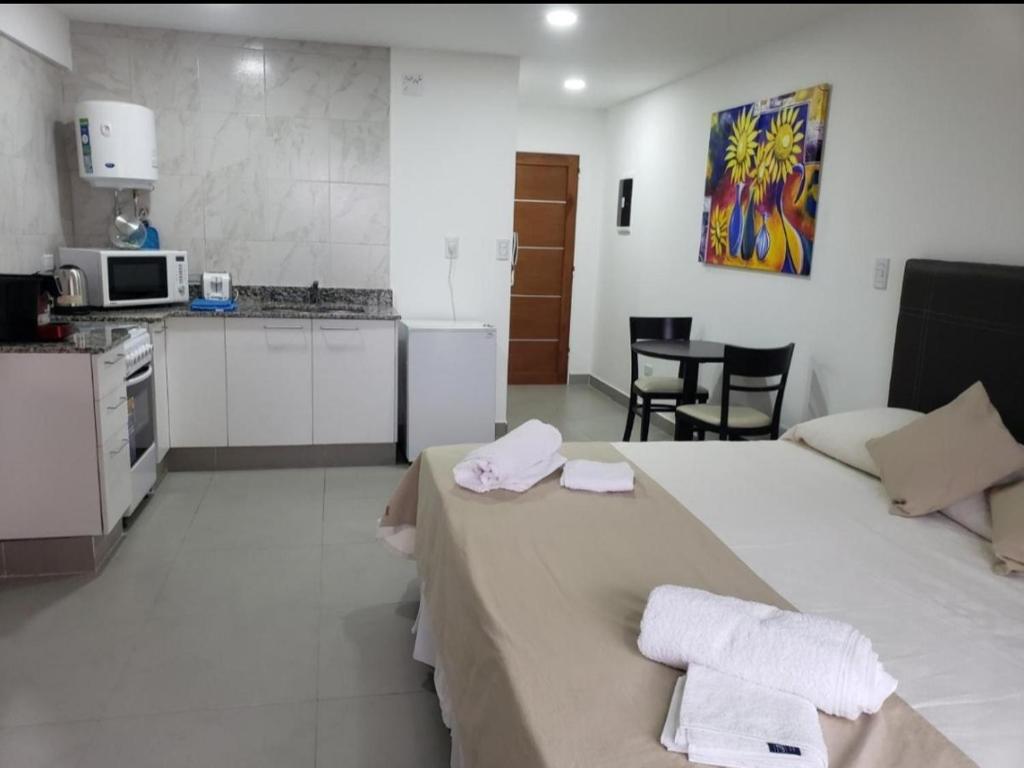 een kamer met een keuken en een bed met handdoeken erop bij Depto Guemes in Salta