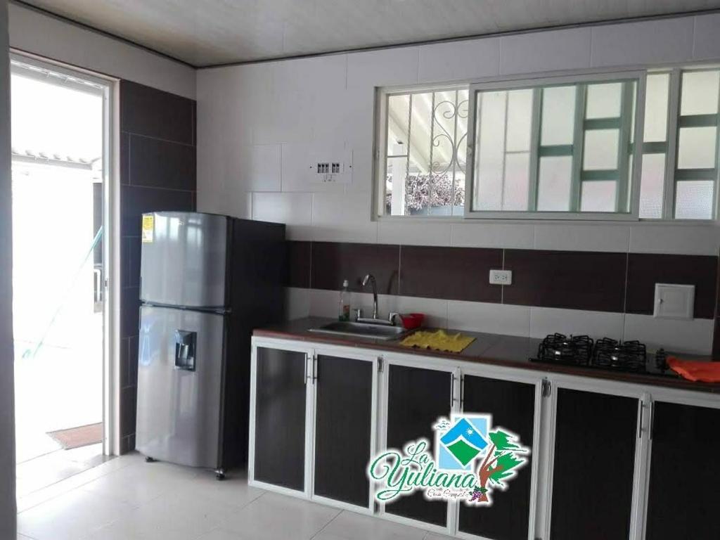 a kitchen with a stainless steel refrigerator and a window at Casa Campestre La Yuliana in Santa Helena