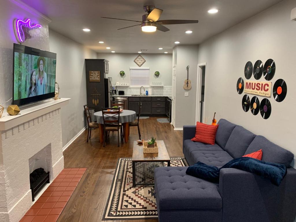 a living room with a blue couch and a fireplace at Rock & Roll House, Fiber Internet, ROKU TV, Washer & Dryer, by DT Chickasha & Leg Lamp! in Chickasha