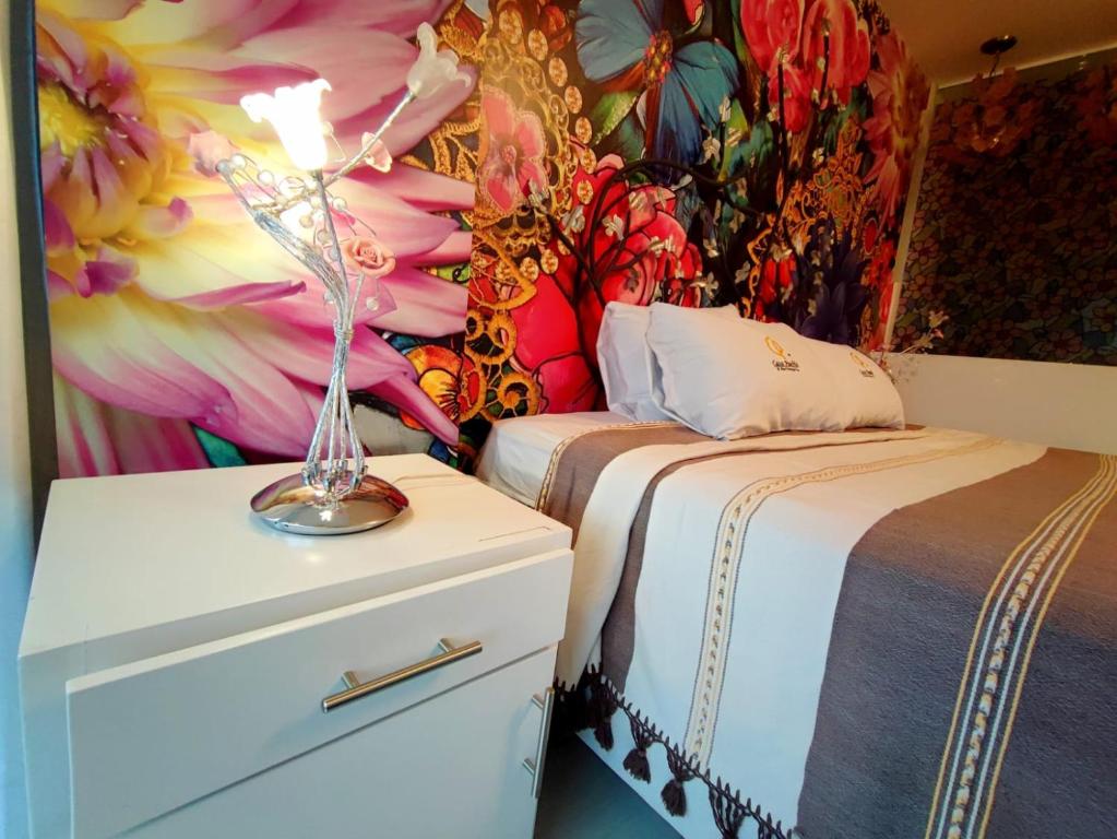 1 dormitorio con 2 camas y vestidor con un mural de flores en Hotel Temático Casa Puebla, en Puebla