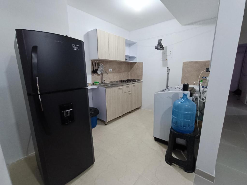 cocina con nevera negra en una habitación en Apartamento Portal de la Sierra 3 Habitaciones, en Santa Marta