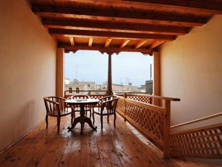 a dining room with a table and chairs on a balcony at Islambek Khiva in Khiva