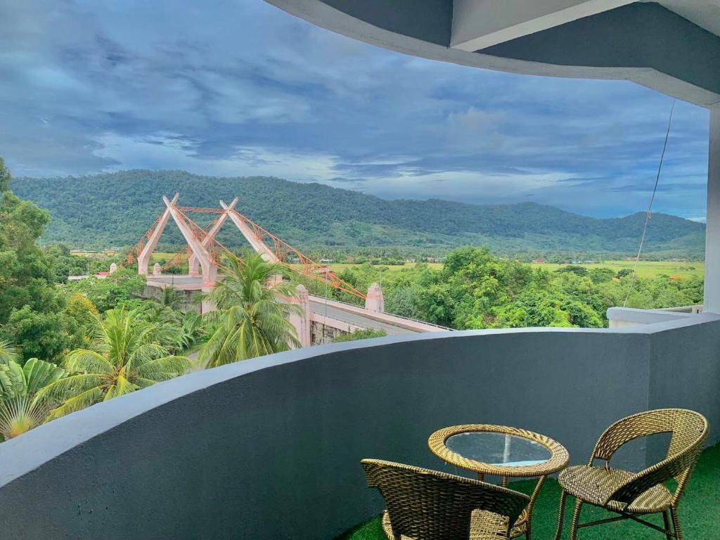 two chairs and a table on a balcony with a view at Perdana Serviced Apartment & Resorts in Kampung Padang Masirat