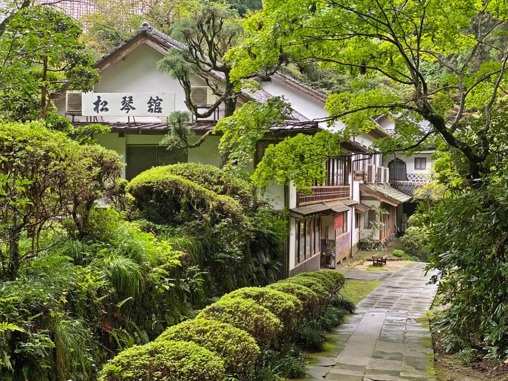 ścieżka przed domem z krzakami w obiekcie Shokinkan w mieście Yasugi
