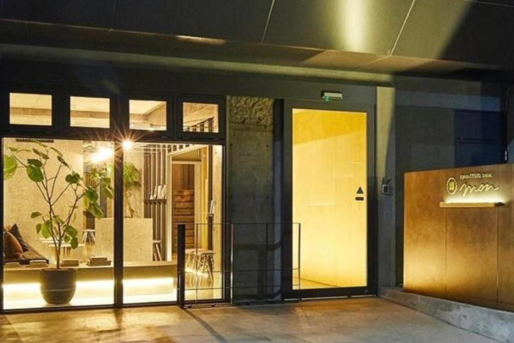 a door to a building with a plant in the window at Kyoto ITOYA Hotel Mon in Kyoto