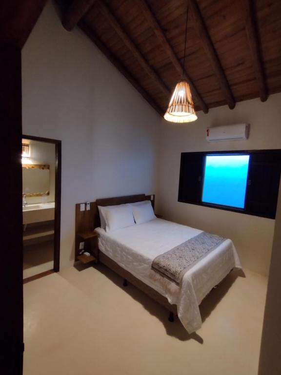 1 dormitorio con 1 cama y TV grande en Casa Harmonia, com 5 suítes em Trancoso-BA en Trancoso