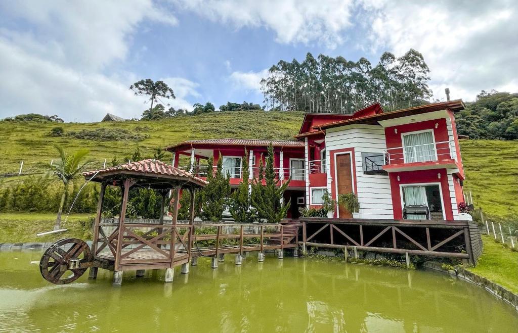uma casa sobre um corpo de água com um barco em AMPLA CASA DE CAMPO - MORADA DA SERRA em Aguas Mornas