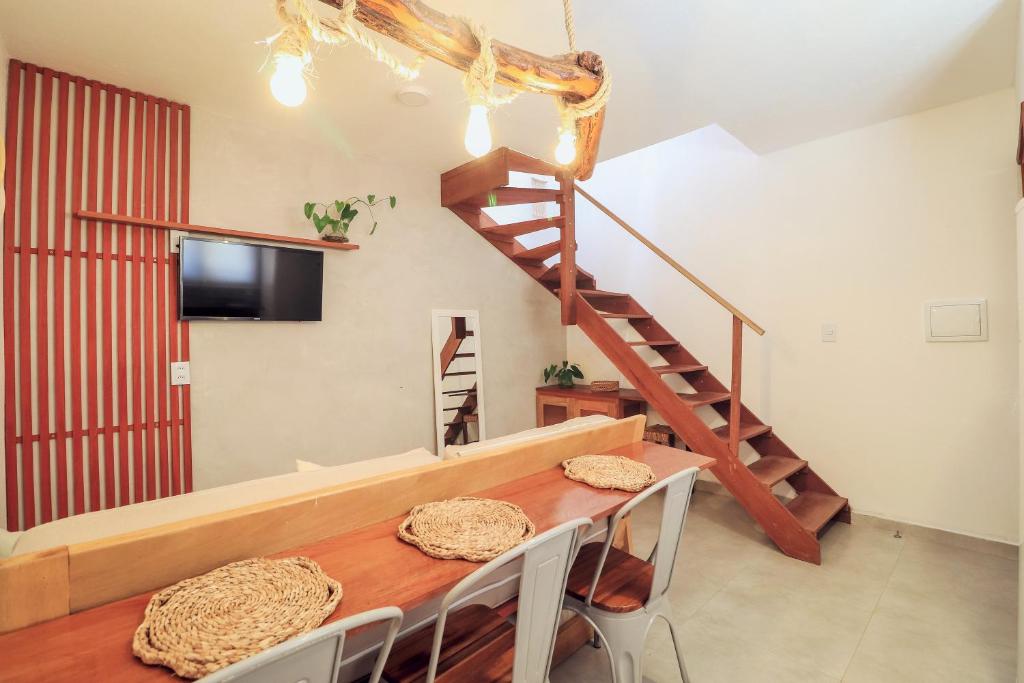 une salle à manger avec une table et un escalier dans l'établissement Apartamento Manay, à Jericoacoara