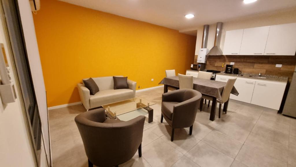 Una sala de estar con mesa y sillas y una cocina. en Pirkas Departamentos, en San Juan