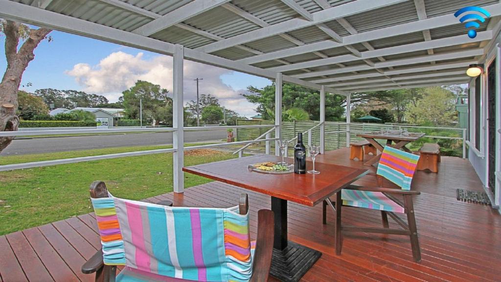 a patio with a table and chairs on a deck at The Marlin in Currarong