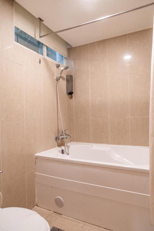 a bathroom with a bath tub and a toilet at Elegance Hotel in Taipei
