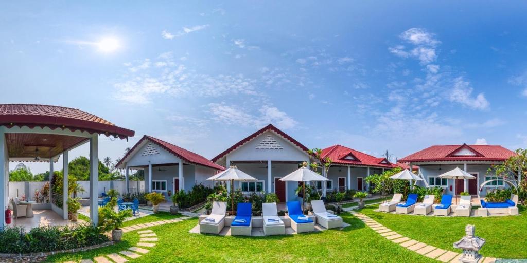 a resort with chairs and umbrellas on the lawn at Langkawi Chantique in Pantai Cenang