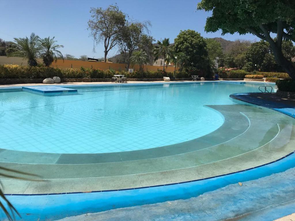 a large swimming pool with blue water at Apartamento Santa Marta Piscina cerca del Rodadero in Santa Marta