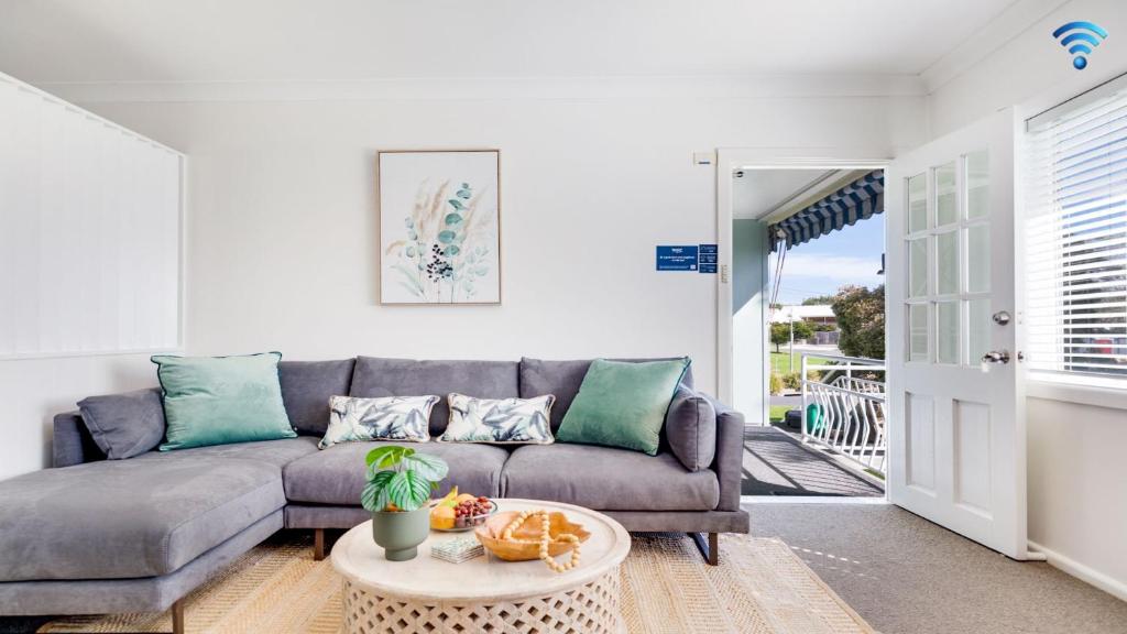 a living room with a couch and a table at Ocean Blue Apartment Three in Currarong
