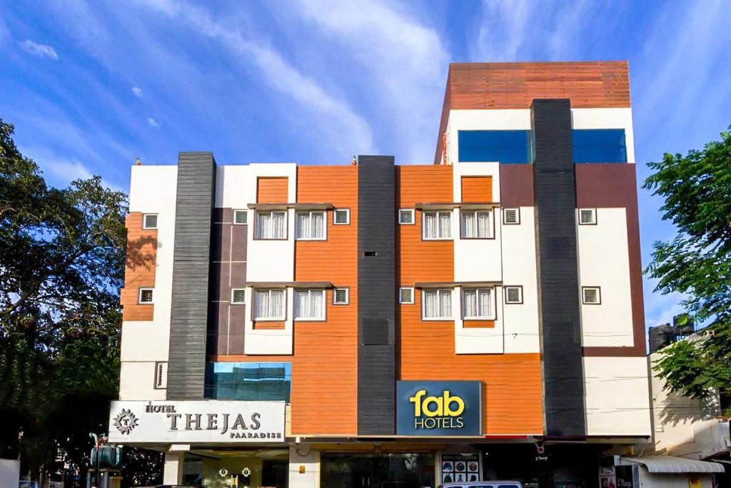 un edificio de color naranja y blanco en FabHotel Thejas Paaradise Coimbatore International Airport, en Coimbatore