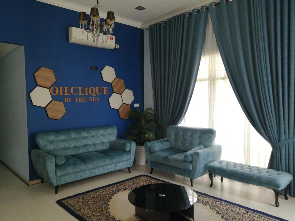 uma sala de estar com duas cadeiras e uma parede azul em Oilclique By The Sea Guesthouse em Dungun