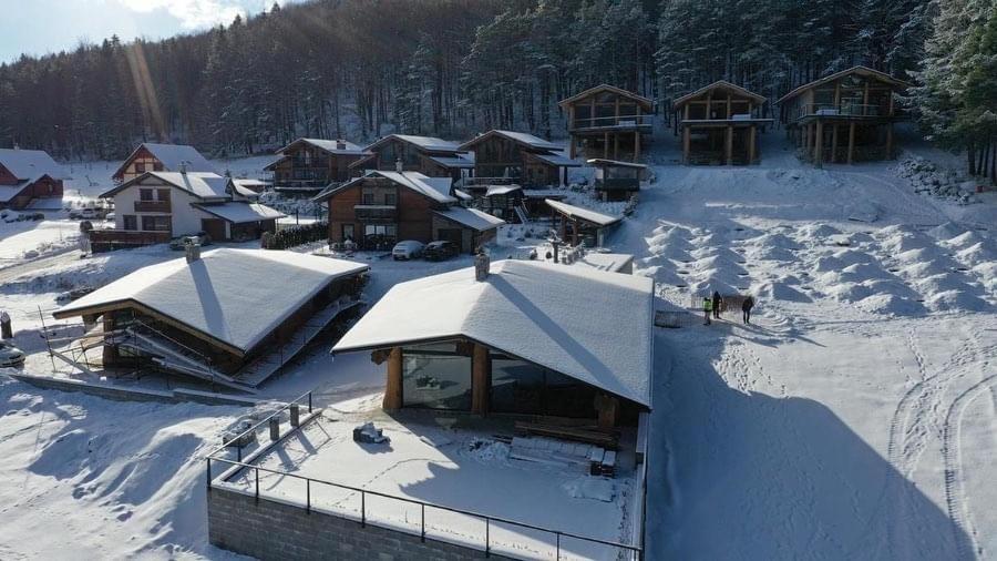 a ski lodge in the snow with snow covered roofs at Mountain Chalets Valča -hobitie domy in Stará Turá