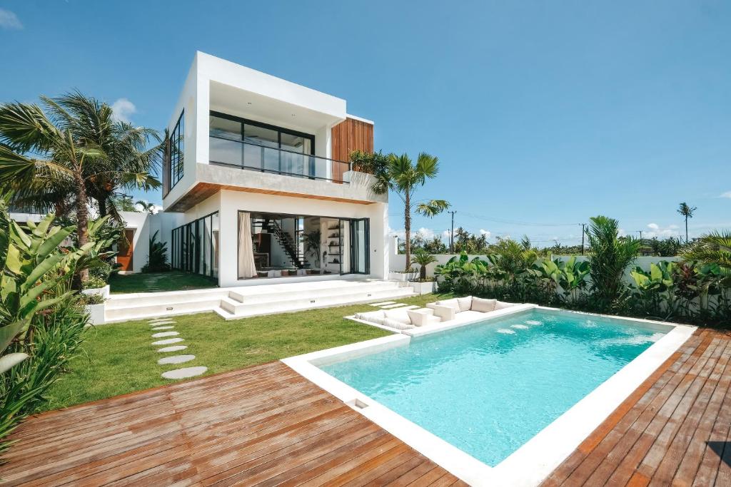 uma villa com piscina em frente a uma casa em Botanique Villa & Studio em Tanah Lot