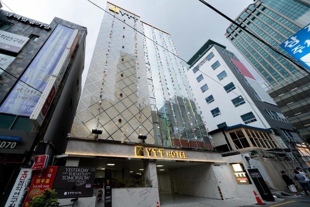 un edificio alto con un cartel de hotel en una ciudad en Ytt Hotel en Busan