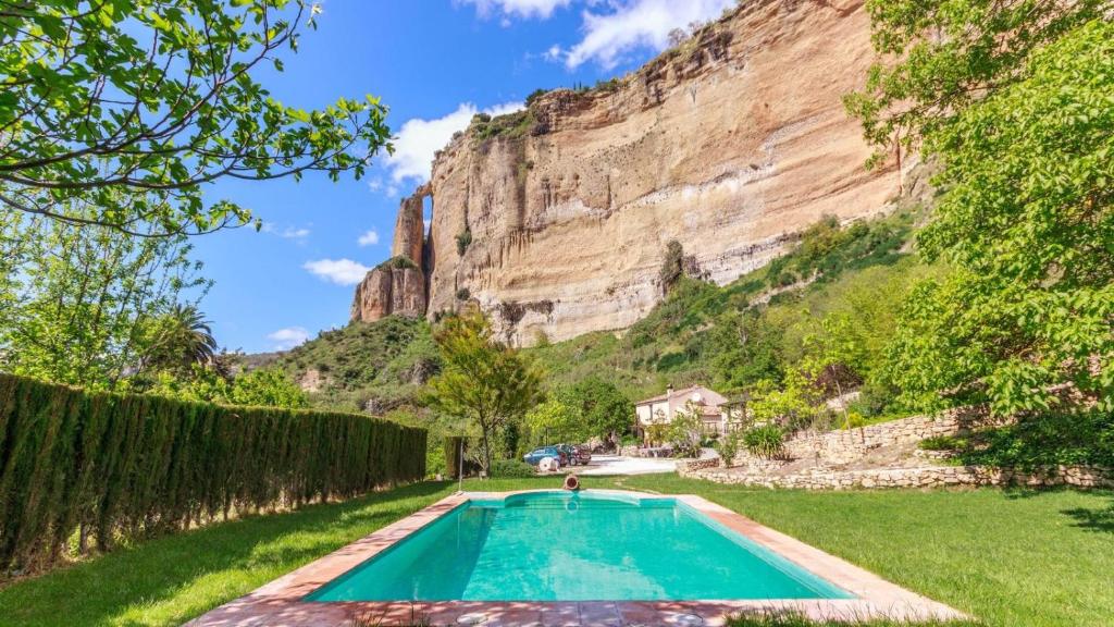 a swimming pool in front of a mountain at La Huerta del Tajo - Pequeña Ronda by Ruralidays in Ronda