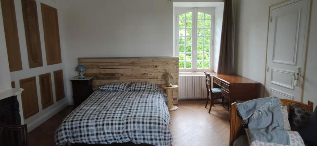 een slaapkamer met een bed, een bureau en een raam bij Maison de Maître - chambre chez particulier in Landéan