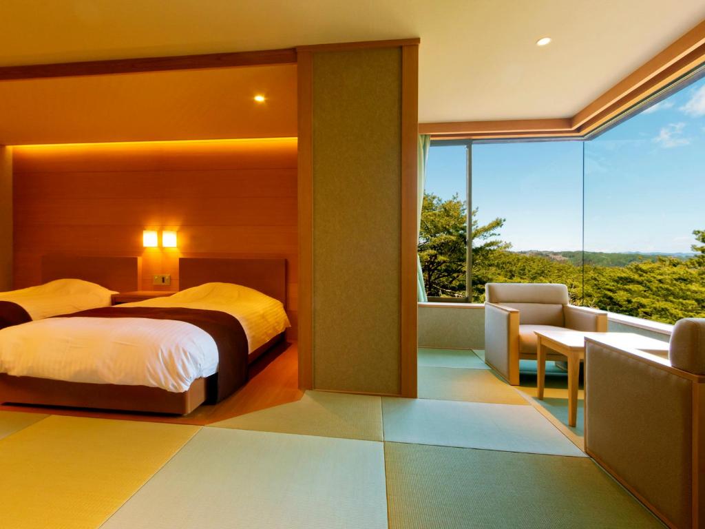 a bedroom with a bed and a balcony at Jodogahama Park Hotel in Miyako