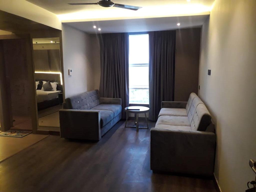 a living room with two couches and a bedroom at Hotel The Legend in Kānpur