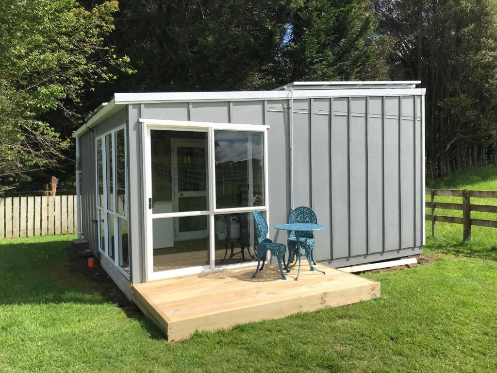 a small shed with a table in the grass at Farmland retreat in Tokoroa