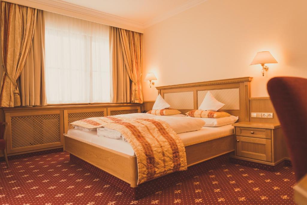 um quarto de hotel com uma cama e uma janela em Gartenhotel Maria Theresia em Hall in Tirol