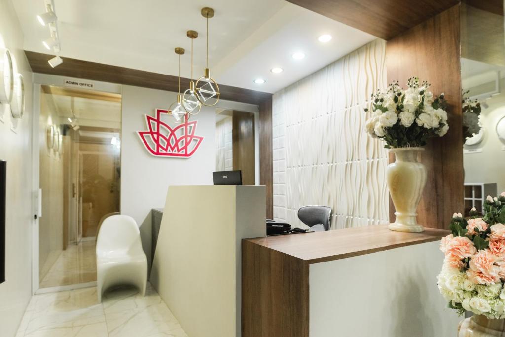 a lobby with a reception desk and flowers at Monica Midtown Suites in General Santos