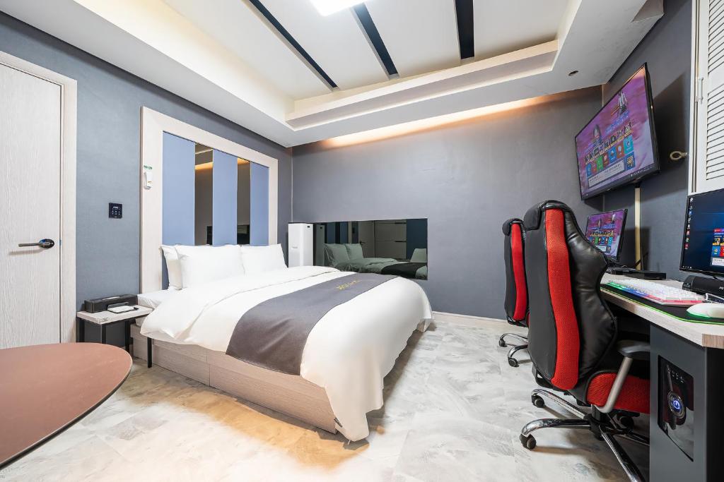 The Nox Hotel في سوون: غرفة نوم مع سرير ومكتب مع جهاز كمبيوتر