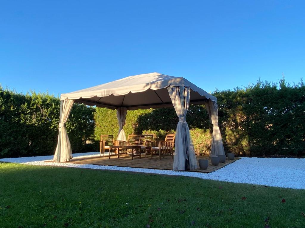 un cenador con una mesa y sillas debajo en El Rincon De Los Abuelos, en Tudela de Duero